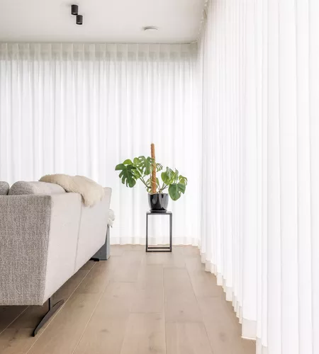 Woonkamer met lange witte gordijnen op maat