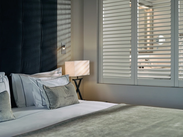 Hotelkamer met bedlinnen en shutters