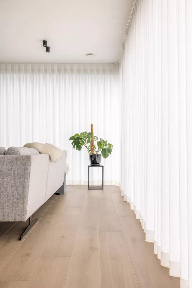 Woonkamer met lange witte gordijnen op maat